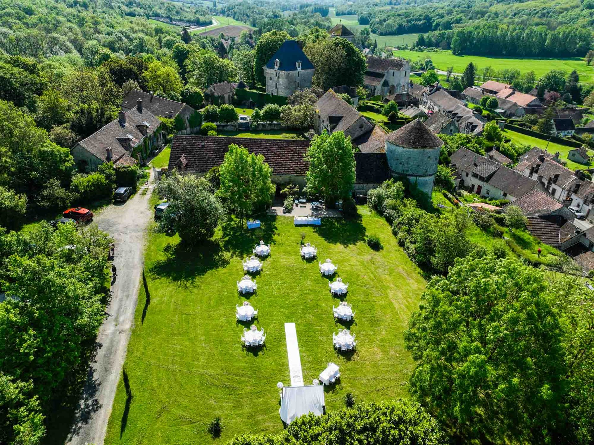 Vue aérienne du jardin dressé pour un mariage — tables rondes et allée centrale